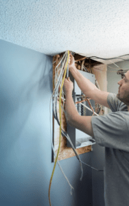 Homme réparant une boîte électrique